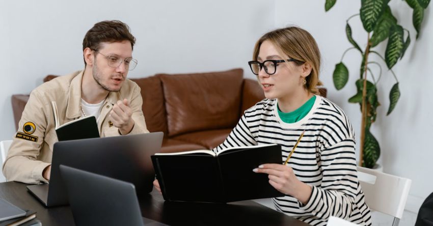 Prioritizing Tasks - Man and Woman Discussing in Workplace