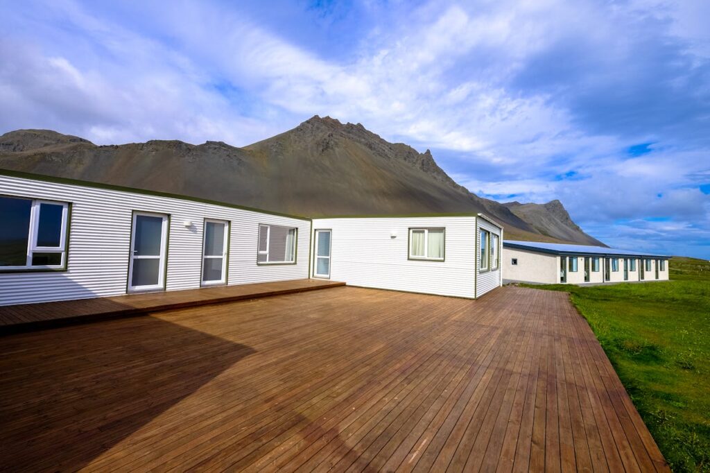 mountain-across-houses-on-green-grass-field-under-clear-blue-sky