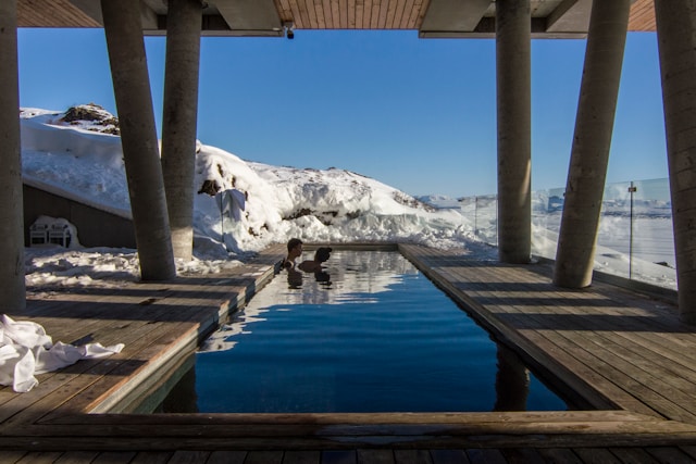 two-person-taking-bath-on-pool-with-distance-to-glacier-mountain